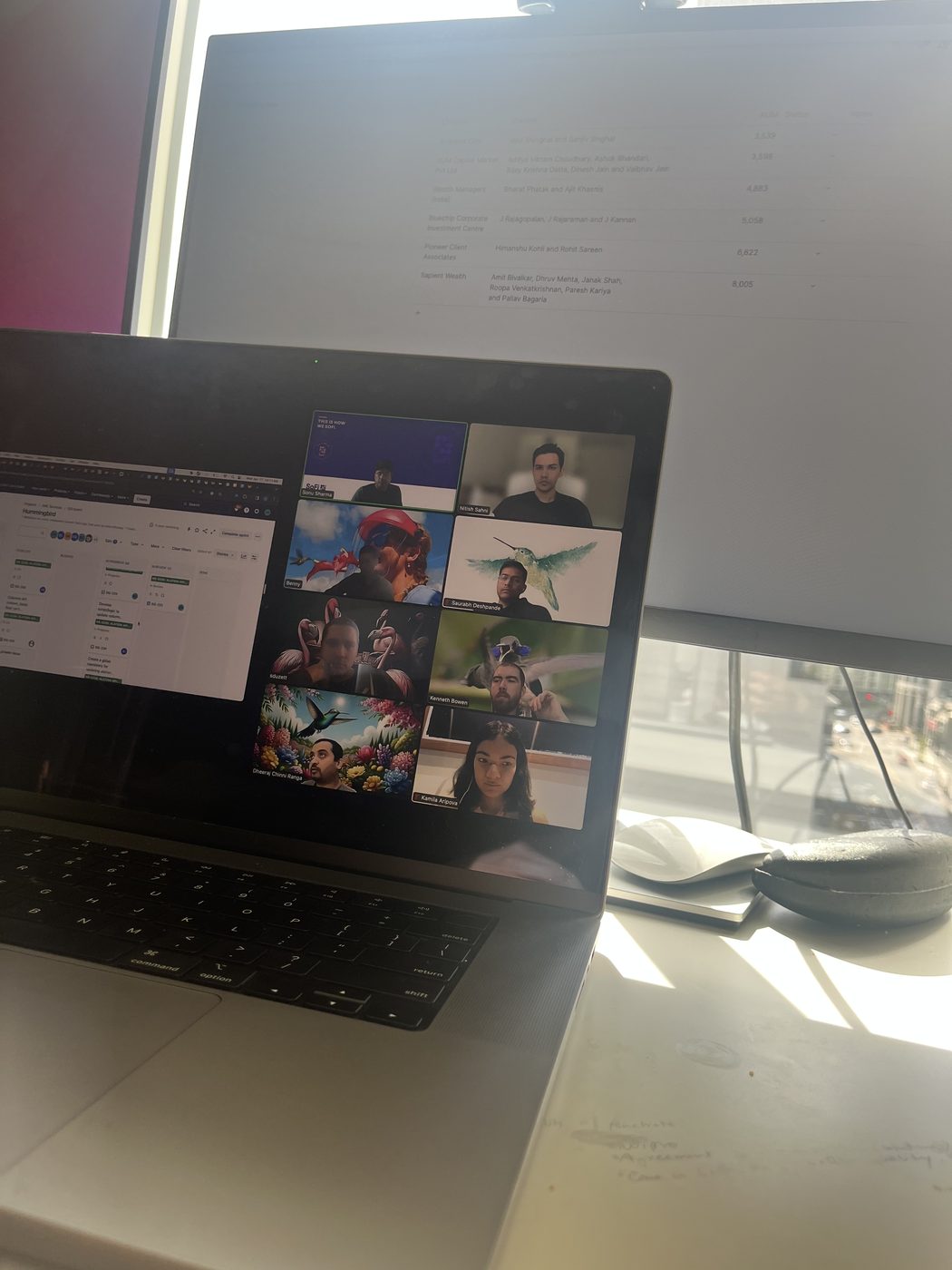 Laptop on a video call in front of a monitor