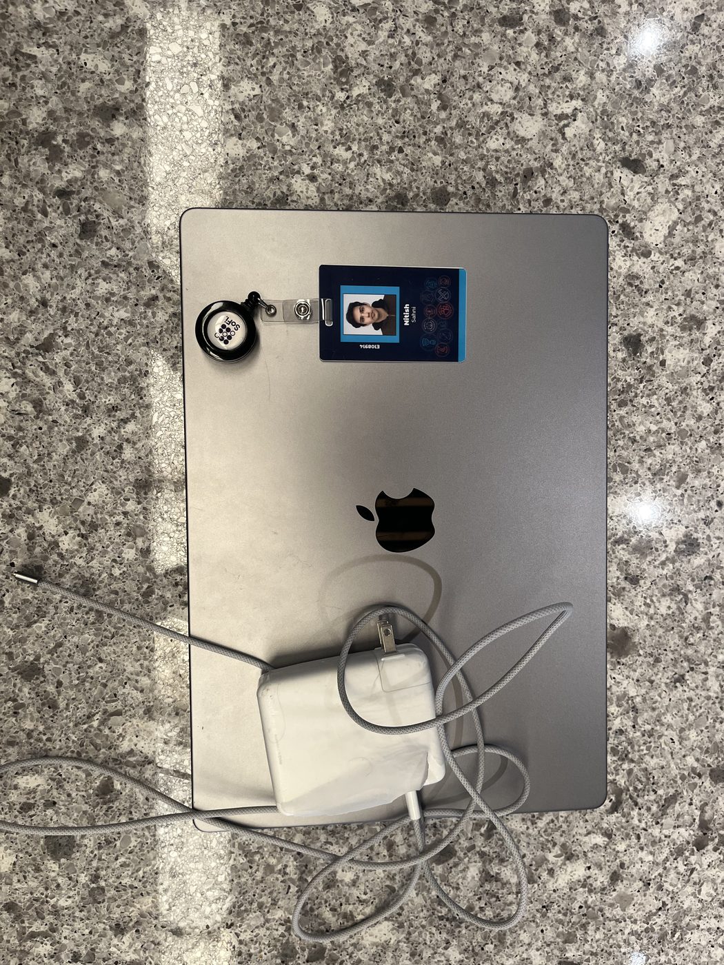 Work badge resting on a laptop on a granite counter